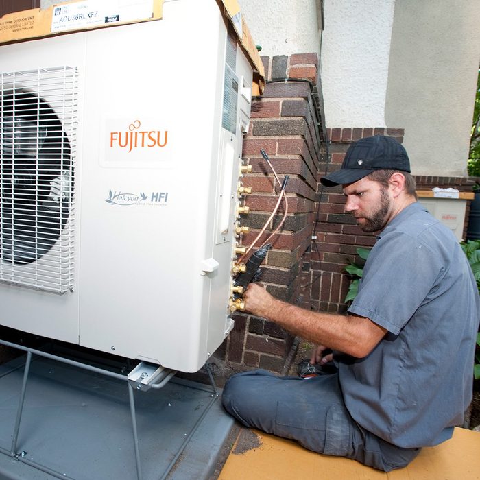 Man installing a mini-split | Construction Pro Tips