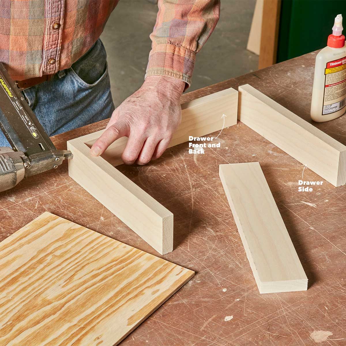 A hand assembles wooden pieces labeled "Drawer Front and Back" and "Drawer Side" on a workbench in a workshop environment.