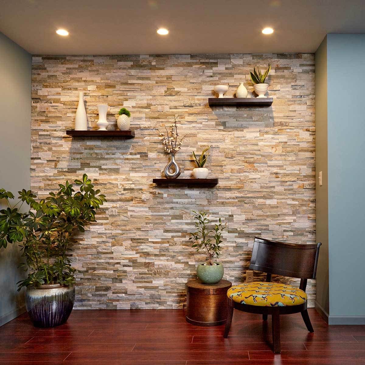 A cozy corner features a wooden chair with a patterned cushion, surrounded by decorative plants on a stone wall with floating shelves displaying vases.