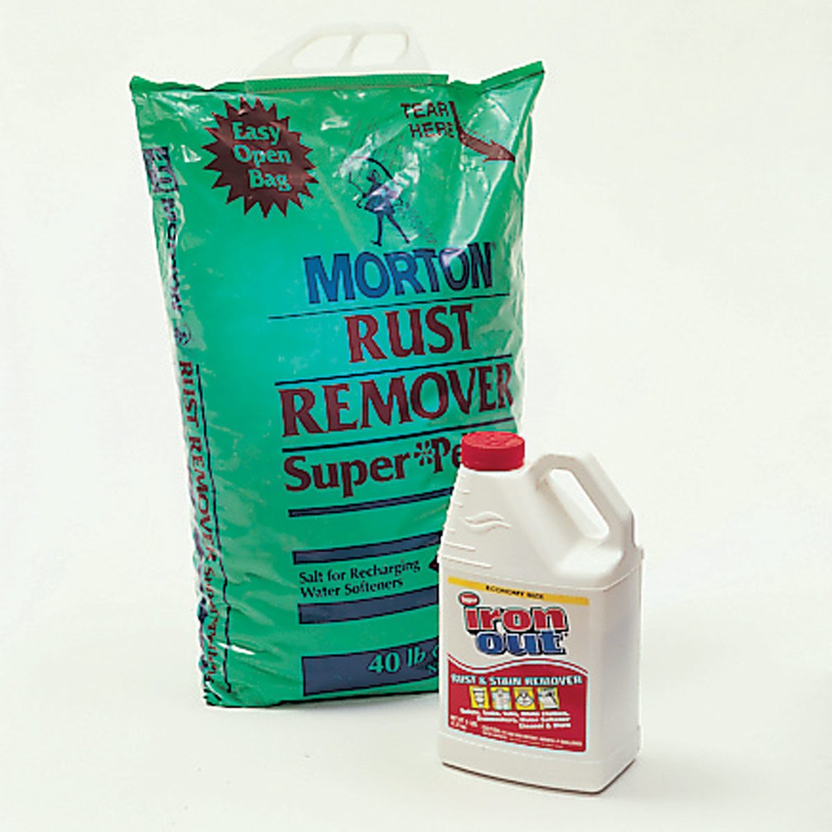 A green bag of Morton Rust Remover stands next to a white bottle of Iron Out. Both are cleaning products against a plain background.