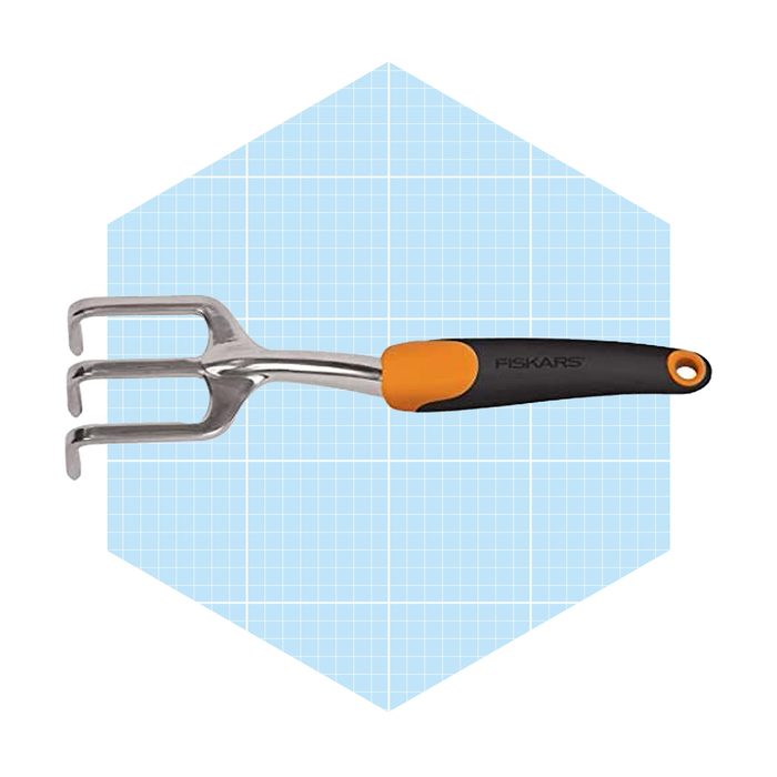 A three-pronged garden cultivator with a metal head and an ergonomic orange and black handle is displayed on a light blue grid background.