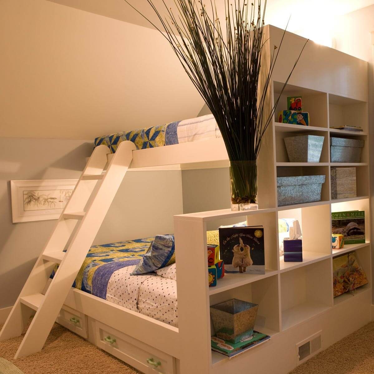 A bunk bed with colorful bedding occupies a cozy room. A ladder leads to the top, while shelves display books and storage boxes nearby.