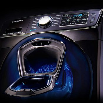 A washing machine with a shiny, modern design is open, showcasing its interior illuminated with blue light, set against a dark background.