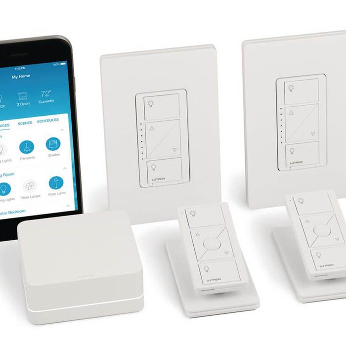 A smartphone and several white smart light controls are arranged on a surface, designed for adjusting lighting in various rooms through a connected app.