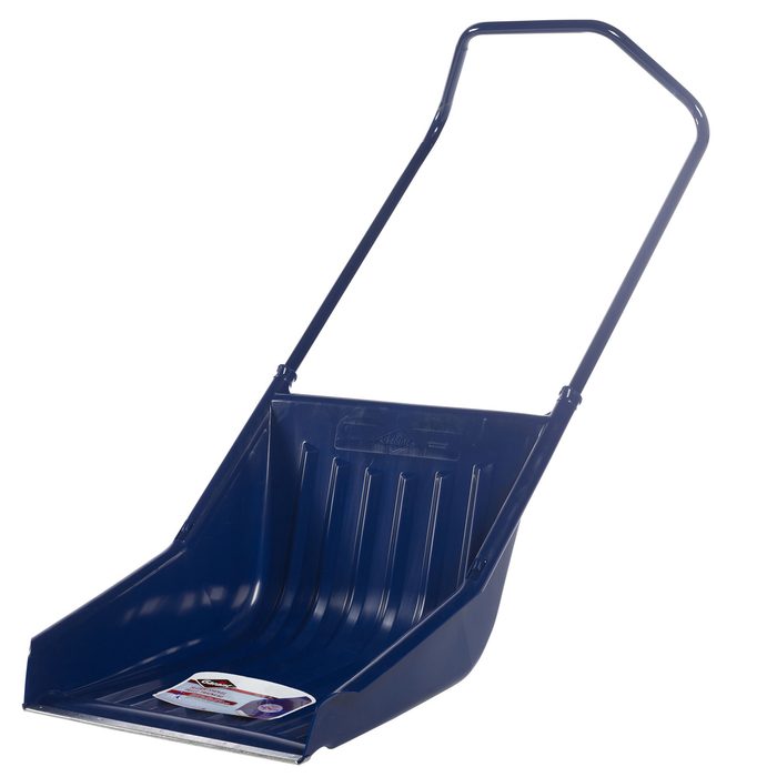 A dark blue shovel with a long handle is positioned upright, designed for scooping materials in outdoor settings like snow or dirt.
