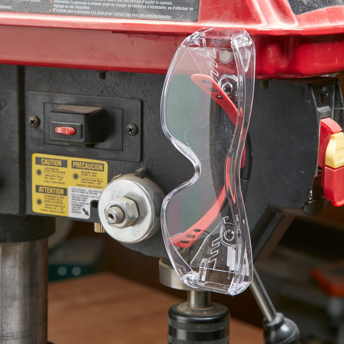safety glasses hanging from large power tool