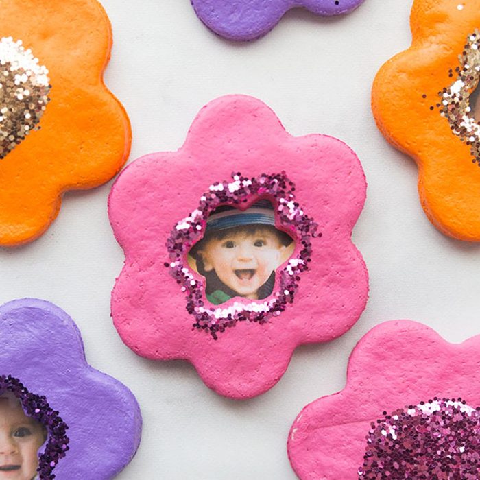 Colorful, flower-shaped decorations feature cut-out windows showcasing smiling children