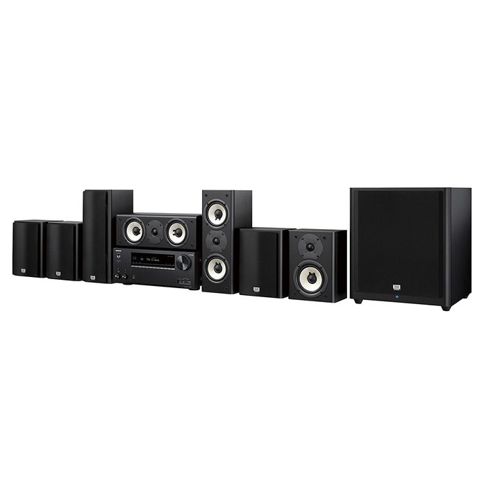 A black audio system features various speakers and a central unit, arranged in a line, designed for surround sound in a domestic environment.