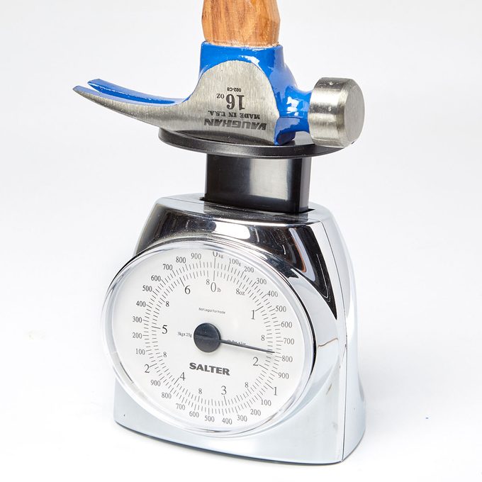 Weighing all the options Hammer head being weighed on a scale | Construction Pro Tips
