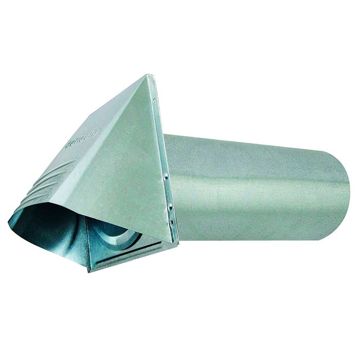 A duct pipe is connected to a roof cap, surrounded by insulation and foil tape, inside a wooden roof structure.