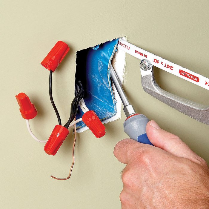 Pushing in an electrical outlet box with a screwdriver | Construction Pro Tips