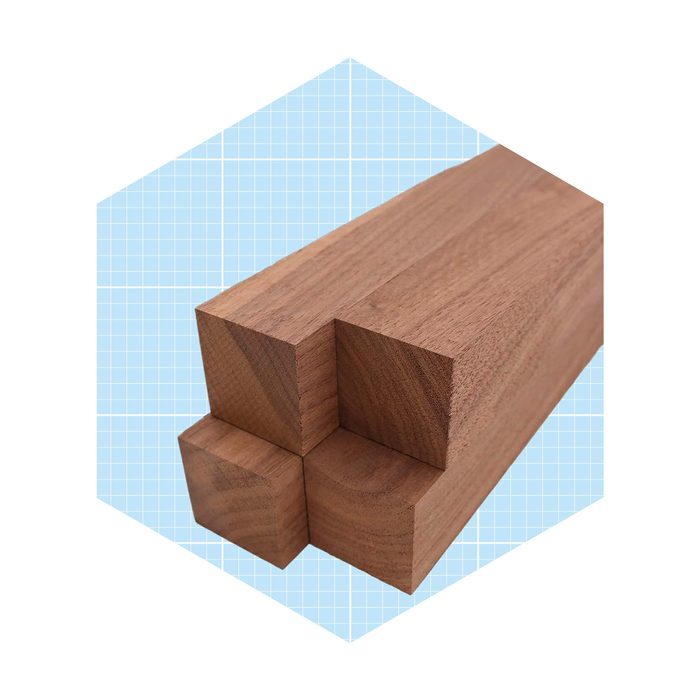 Three wooden blocks are arranged together, displaying smooth surfaces and sharp edges, set against a light blue grid background.