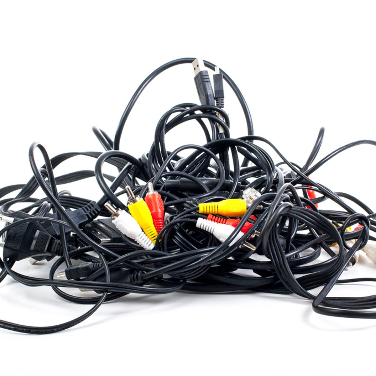 A tangled mass of black cables with red, yellow, and white connectors sits on a white surface, suggesting disorganization in a digital or audio environment.