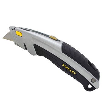 A retractable utility knife with a silver metal body and black rubber grip rests on a plain white surface, ready for cutting tasks.