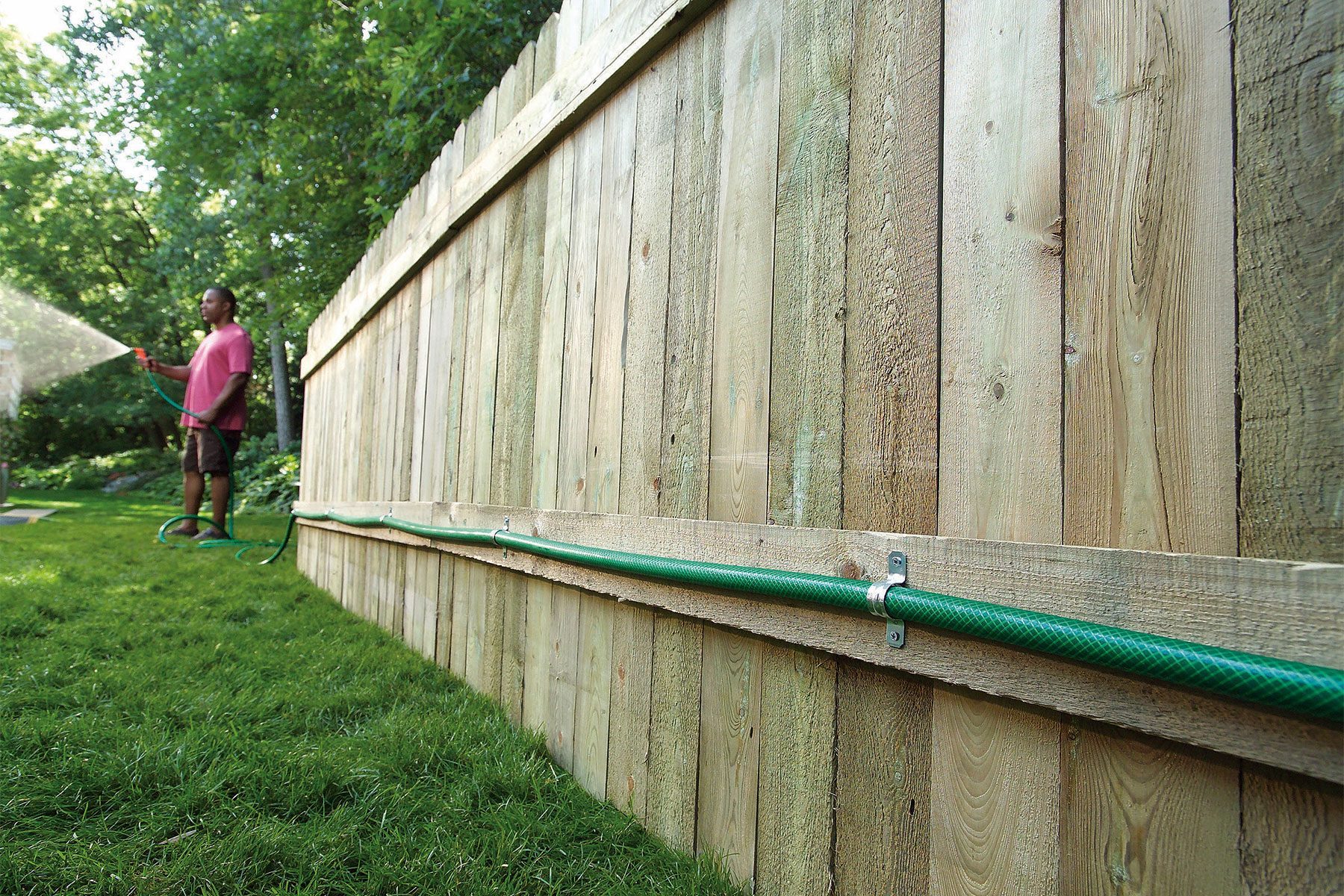Man Watering the lawn with hose