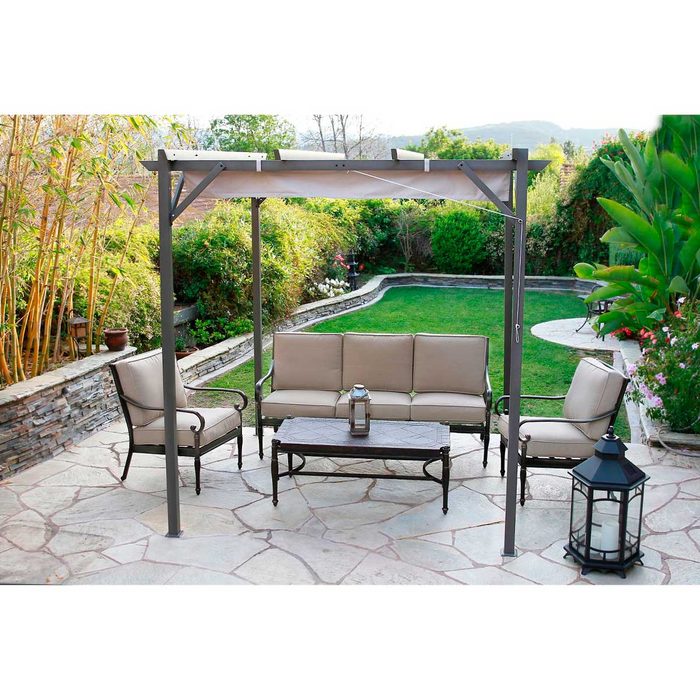 A metal-framed gazebo shelters a seating area with beige furniture and a table, surrounded by a landscaped garden and stone pathways.