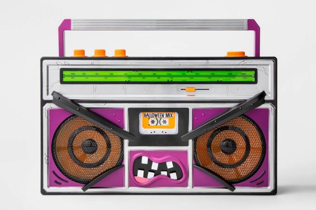 A colorful boombox displays a playful design, featuring exaggerated facial elements, orange buttons, and a "Halloween Mix" label, set against a plain background.