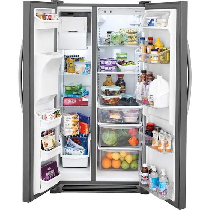 A refrigerator is open, showcasing organized shelves filled with various food items, beverages, and condiments, providing an overview of available groceries and refreshments.
