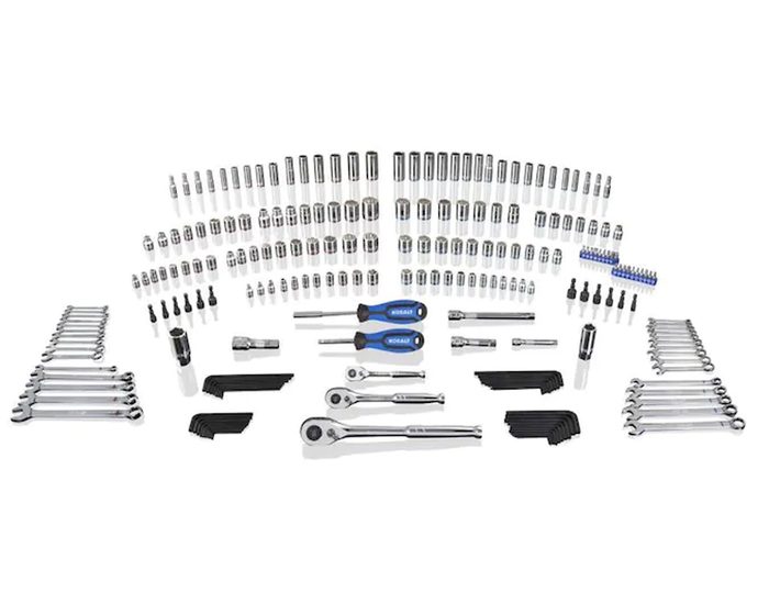 A variety of metal tools, including sockets, wrenches, and ratchets, are organized neatly on a white background, showcasing a comprehensive set for mechanical work.