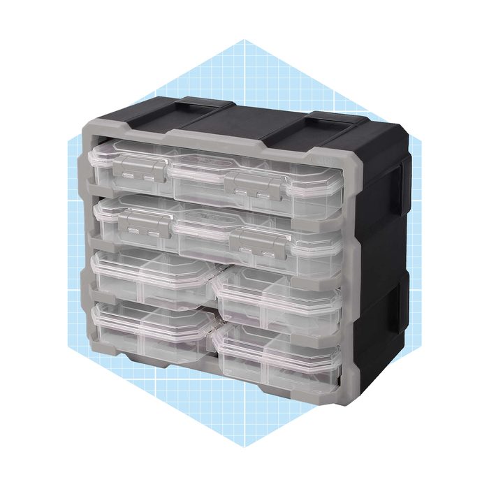 A stack of transparent storage containers is organized on a black base, designed for holding small items, set against a light blue grid background.