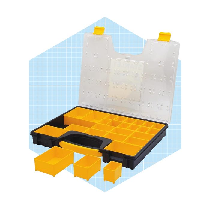 A black storage organizer with a clear lid is open, revealing multiple yellow compartments of varying sizes, set against a light blue grid background.