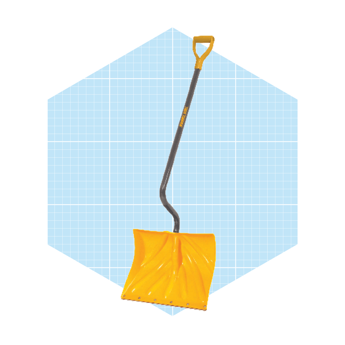 A yellow snow shovel stands upright against a light blue grid background, designed for clearing snow from surfaces like driveways or sidewalks.