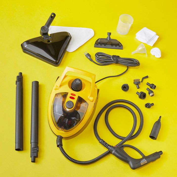 A yellow steam cleaner is displayed with various attachments on a bright yellow background, ready for cleaning tasks.