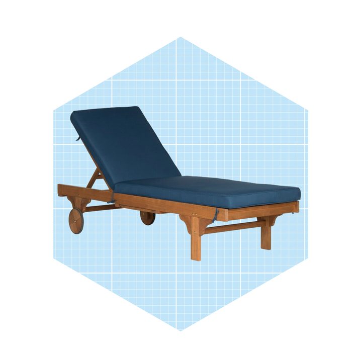 A wooden lounge chair with a blue cushion reclines at an angle, set against a light blue grid background.