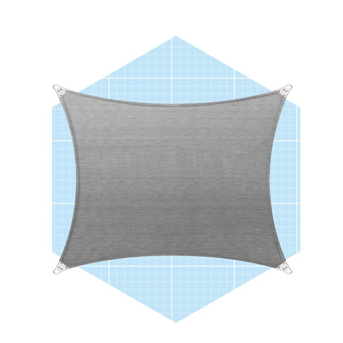 A gray fabric shade sail is secured at the corners, stretched out above a light blue grid background, providing shade in an outdoor setting.