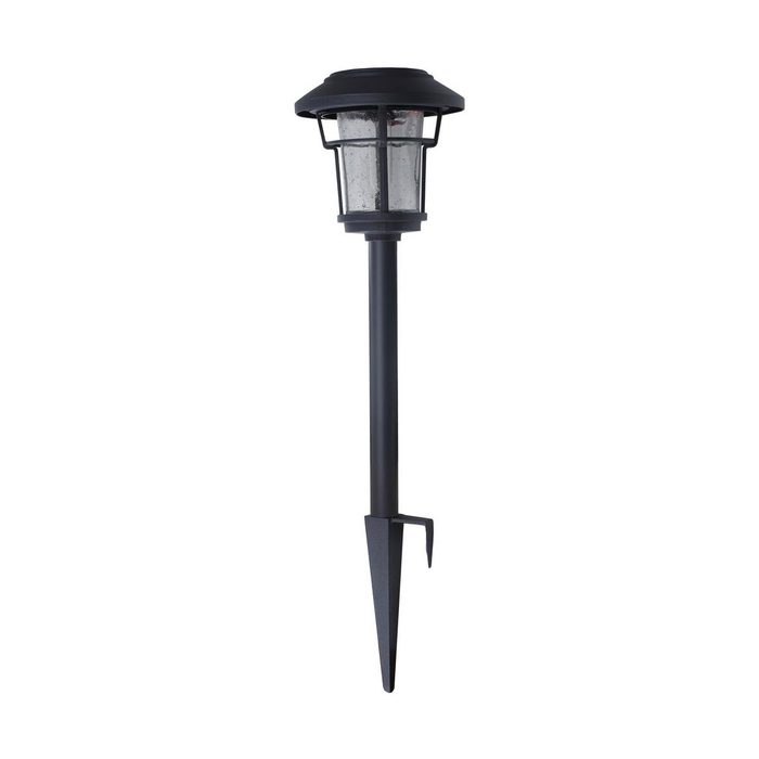 A black garden lantern stands on a pointed stake, designed for outdoor use, illuminating paths or gardens in a nighttime setting.