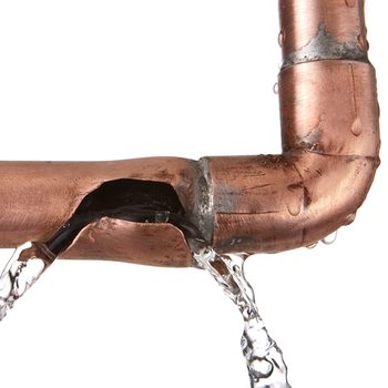 A copper pipe with a visible crack leaks water, creating a stream. The dripping water contrasts with the shiny surface of the copper material.