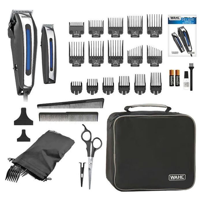 A set of hair clippers and accessories arranged neatly, including combs, scissors, guard attachments, and a carrying case, ready for grooming tasks.