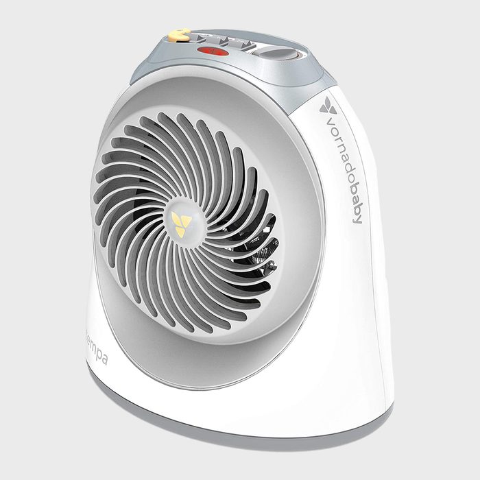 A small, white fan circulates air, featuring a round grille and control buttons on top, placed against a light gray background.