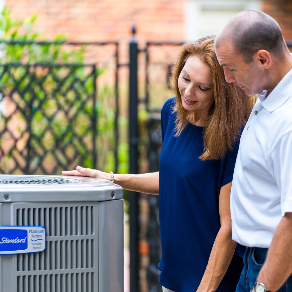 Two people checking out an air conditioner