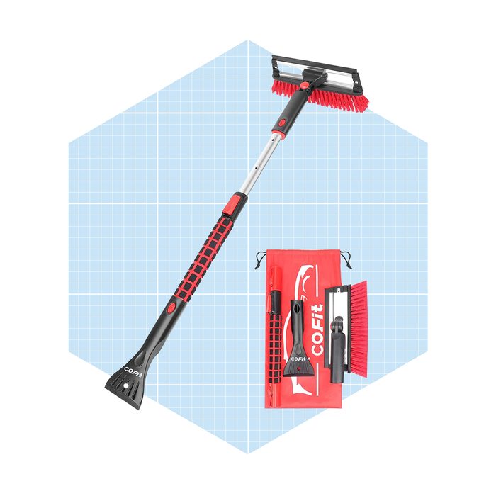 A red and black ice scraper with a brush is positioned upright next to a carrying pouch containing additional cleaning tools, set against a light blue grid background.