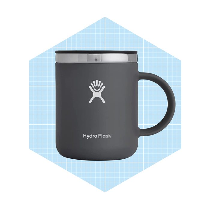 A gray insulated mug rests against a light blue geometric background, designed for beverages while featuring a logo and handle for easy gripping.