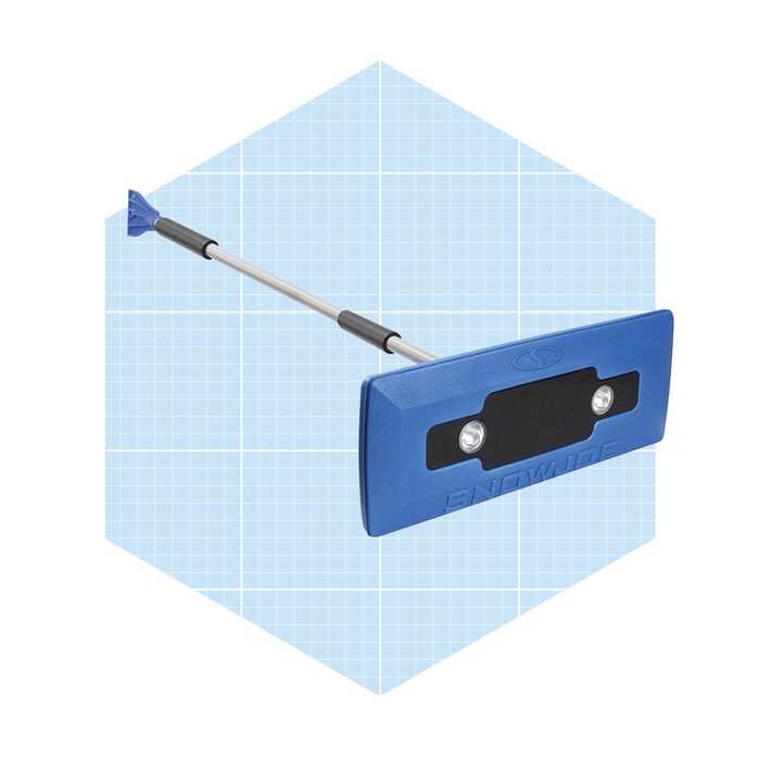 A blue snow shovel features a wide blade and a telescoping handle, designed for clearing snow in a grid-pattern background.