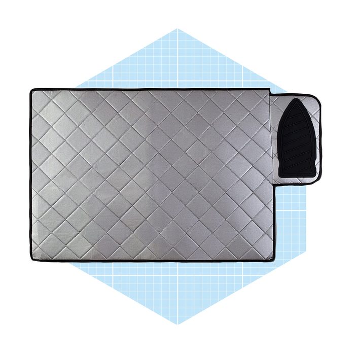 A rectangular, quilted, silver mat with a textured border sits on a light blue, grid-patterned background, creating an organized and modern appearance.