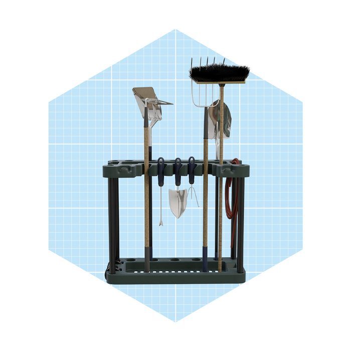 A storage rack displays various garden tools, including a rake, spade, and shovel, organized neatly against a light grid-patterned background.