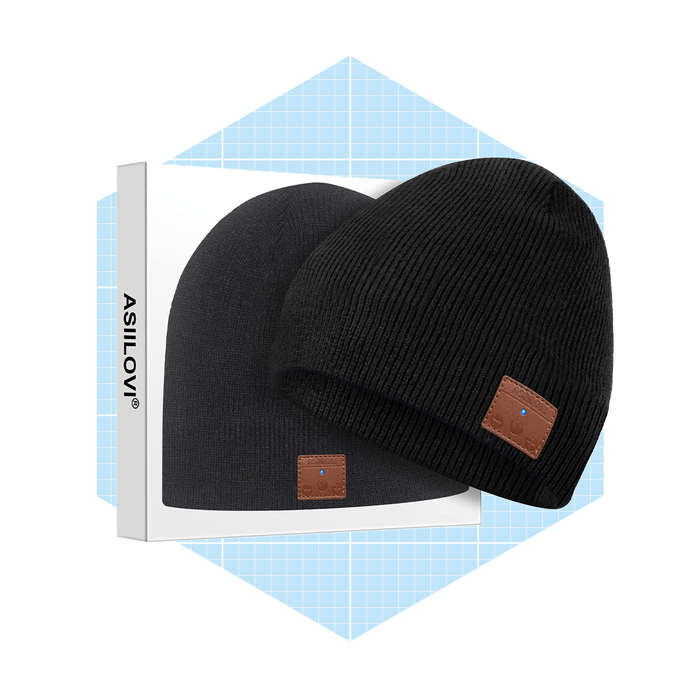 Two black beanies are displayed on a light blue grid background, showcasing a brand label and a leather patch on one hat.