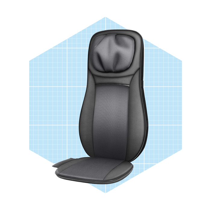 A black massage chair cushion is positioned upright against a light blue grid background, showcasing its ergonomic design and contours for comfort.
