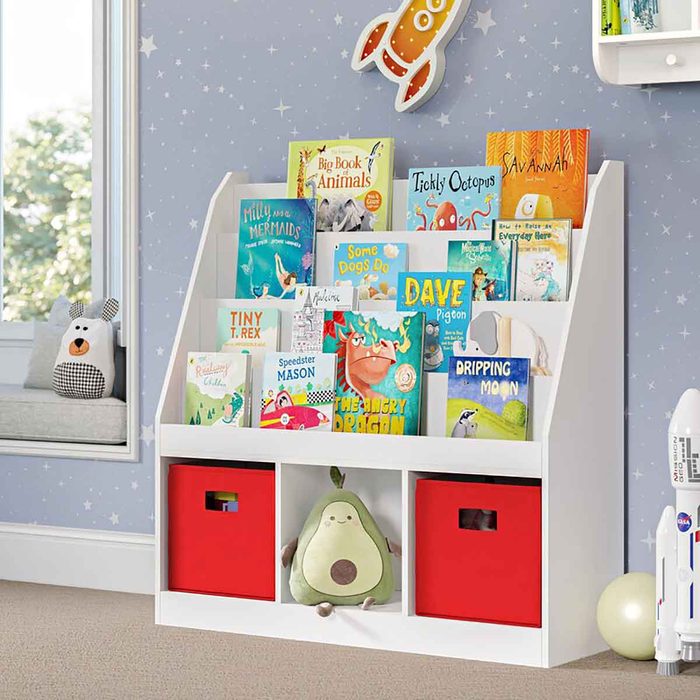 A white bookshelf holds a variety of colorful children