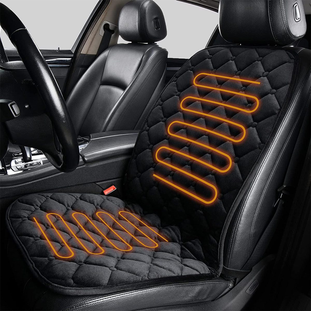 A heated car seat cover is positioned on a black leather car seat, featuring orange heating lines, situated in a vehicle's interior.