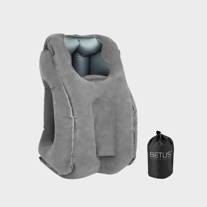 A gray inflatable chair stands upright beside a black carrying bag, suggesting portability. The chair features a hollow center and plush texture for comfort.