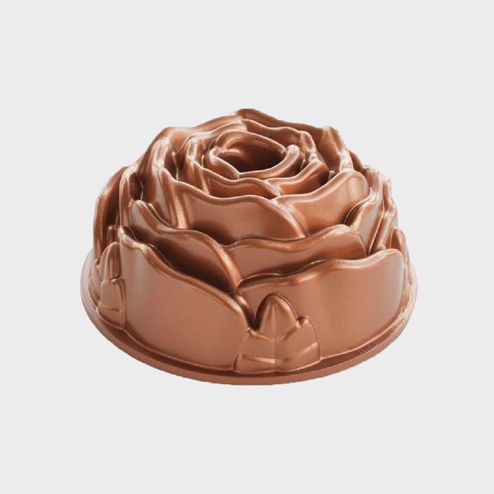 A bronze rose-shaped baking mold sits upright, showcasing intricate petal details, ready for use in a kitchen or baking context.