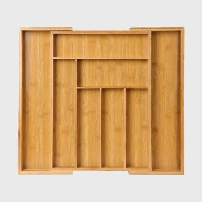 A bamboo tray features multiple compartments, organized for storage. It sits on a plain, light-colored surface, emphasizing its design and functionality.