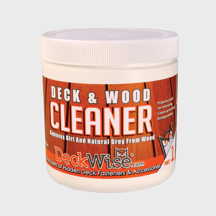 A container of wood cleaner removes dirt and gray from wood surfaces, featuring an orange and white label with product details and a logo.