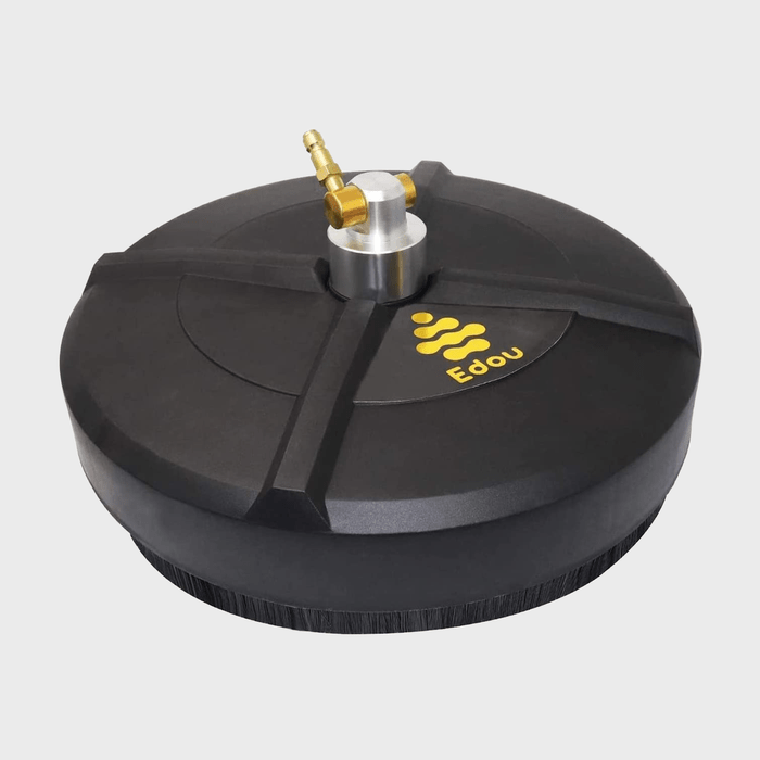 A round, black cleaning tool with a central nozzle is positioned against a plain background, designed for effective surface scrubbing with attached brush fibers.