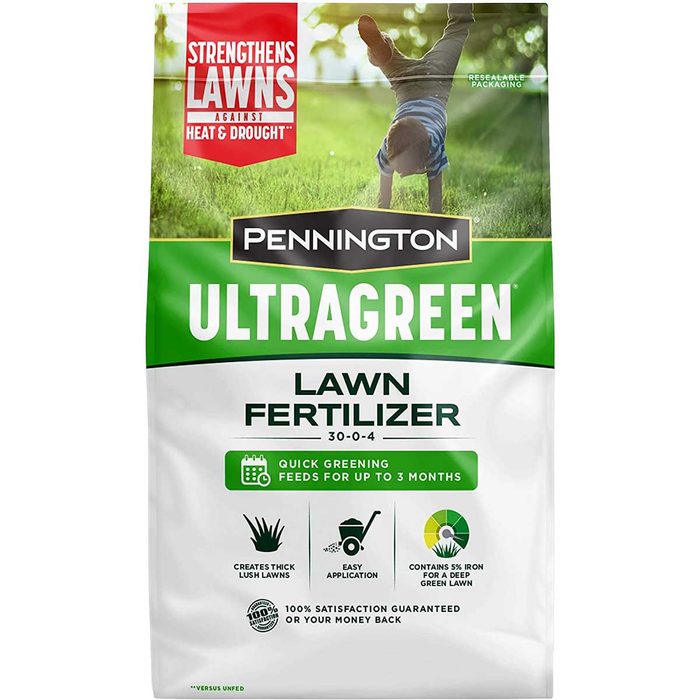 A bag of Pennington UltraGreen lawn fertilizer stands upright. It promotes quick greening for lawns, emphasizing easy application and satisfaction guarantee.