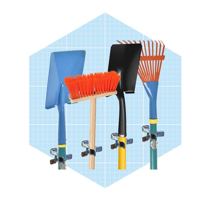 A collection of garden tools—shovel, broom, and rake—are mounted on wall brackets against a light blue grid background.